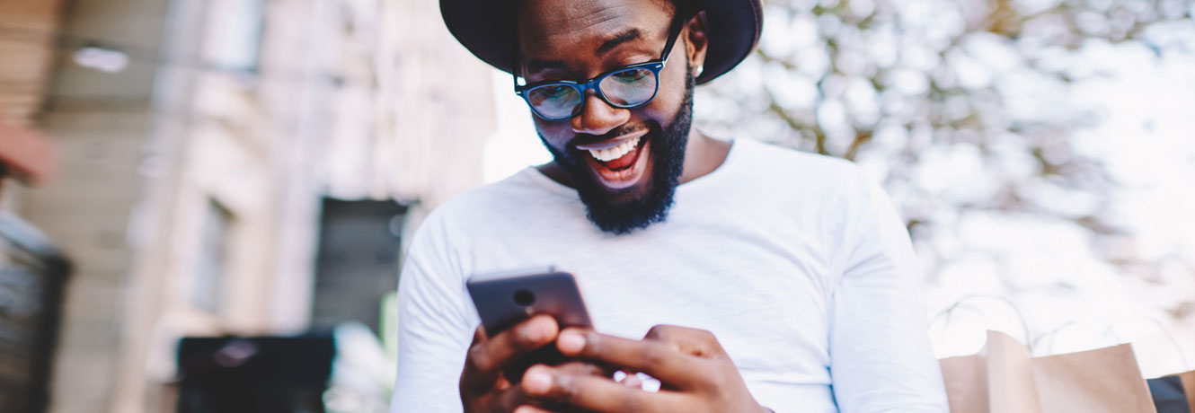 Excited man looks at his phone and realizes he just received an early paycheck.