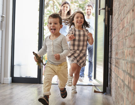 Family enters the front door of their new home.